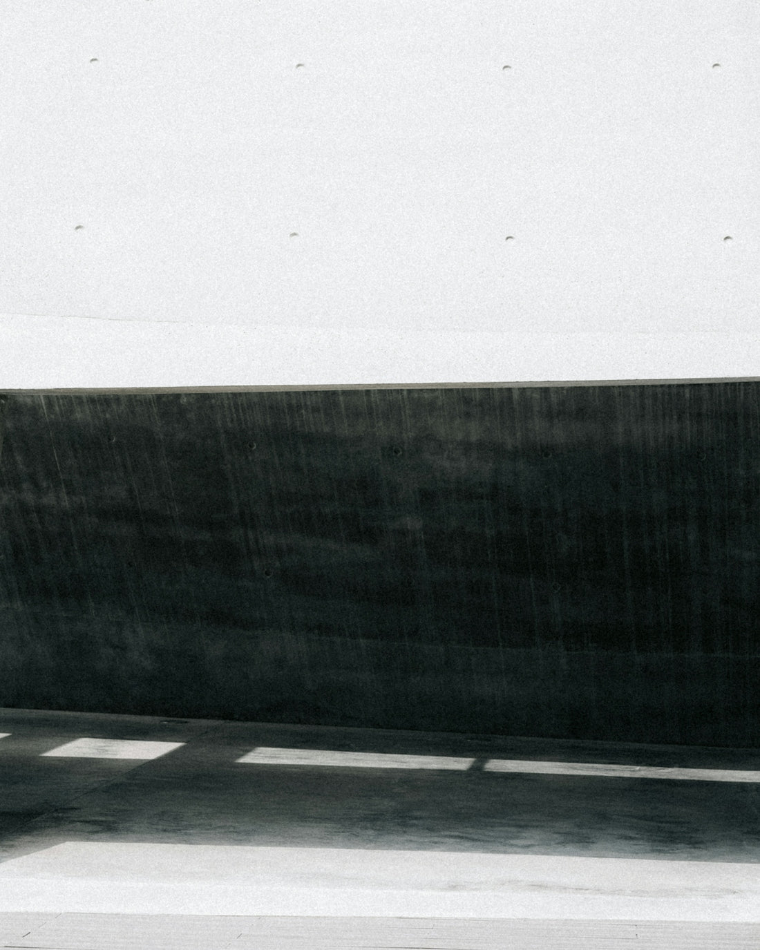 Dark shadows and white concrete create contrast.